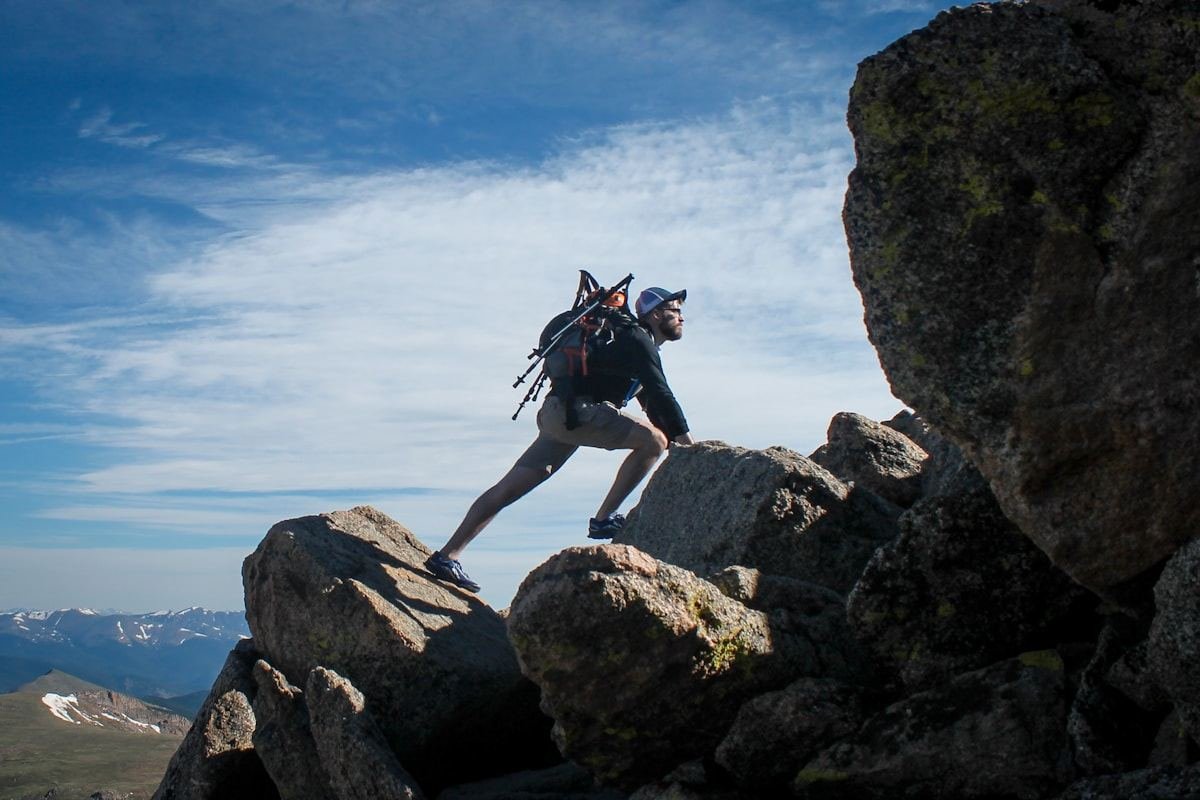 Persona ascendiendo por una ladera rocosa de montaña